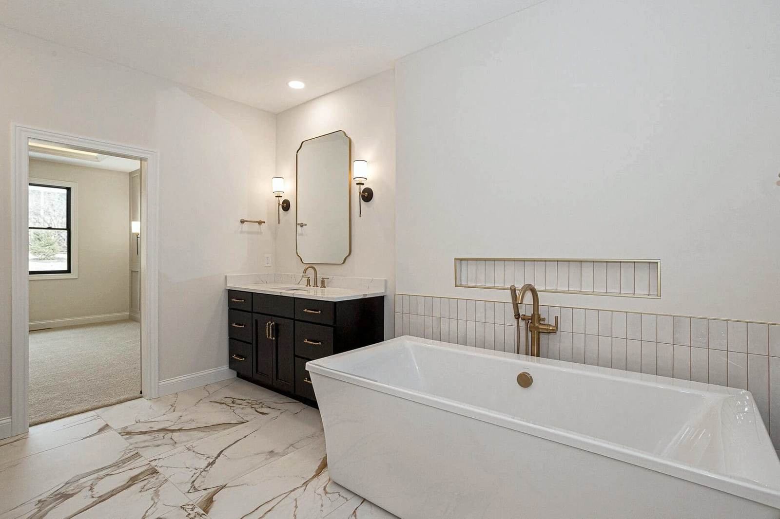 Bathroom with freestanding tub on marble tile